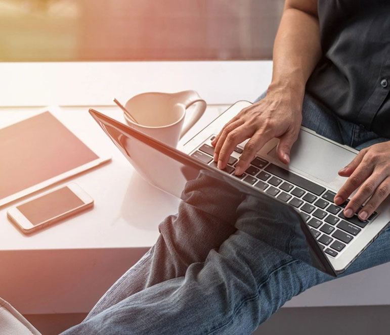 A person sitting at a table with a laptop.