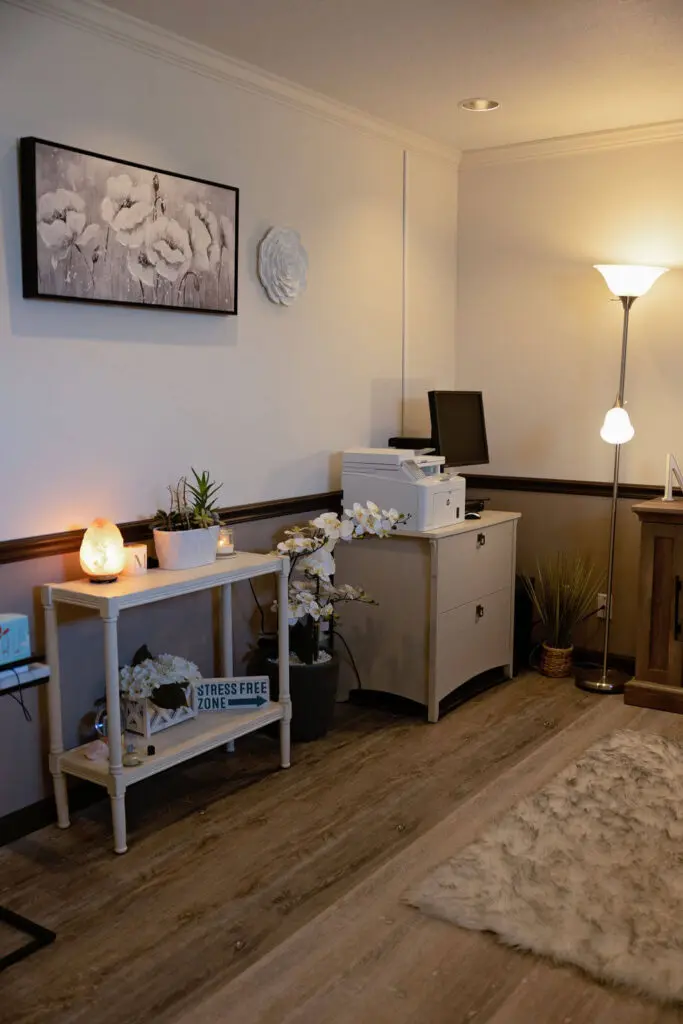 A living room with a desk and lamp