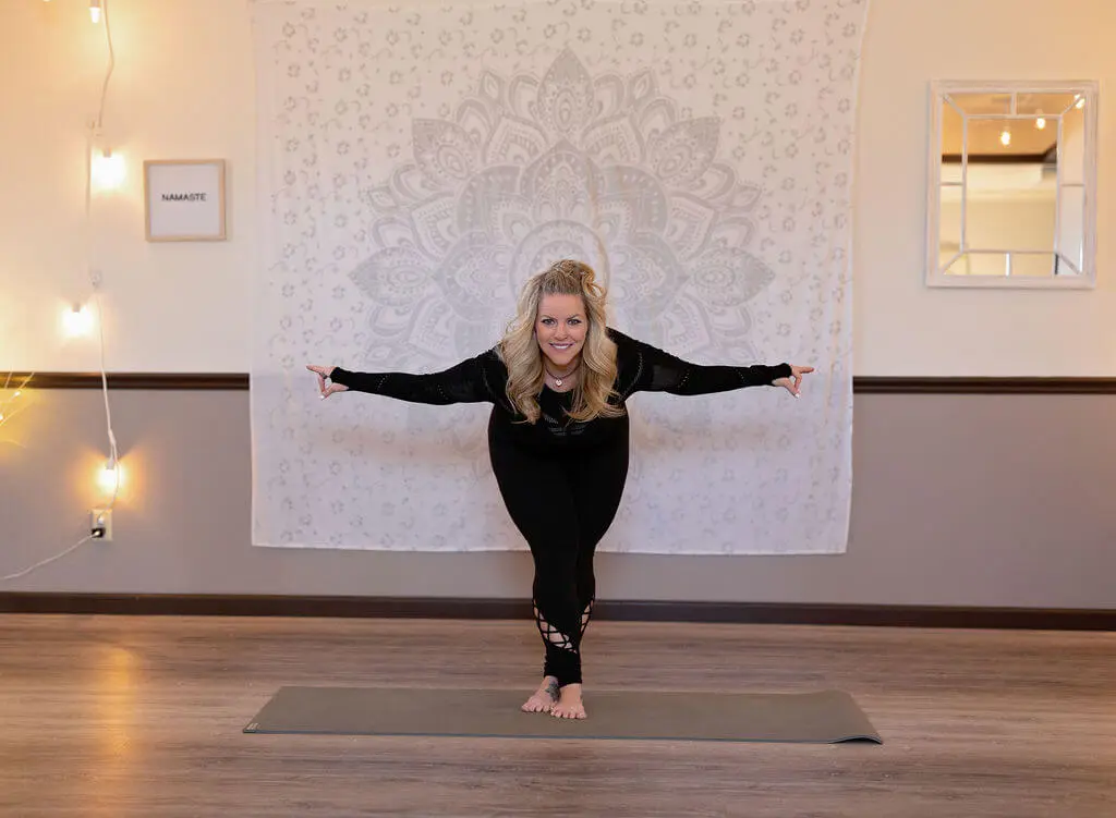 A woman is standing on her hands in the middle of a yoga pose.