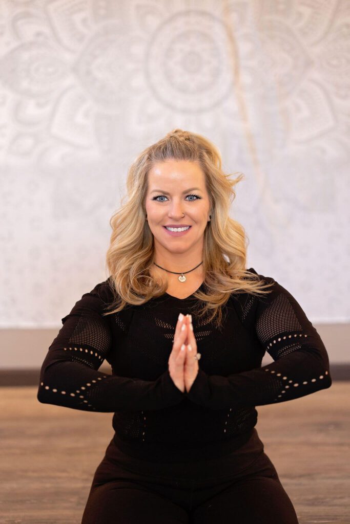 A woman in black shirt with her hands up.