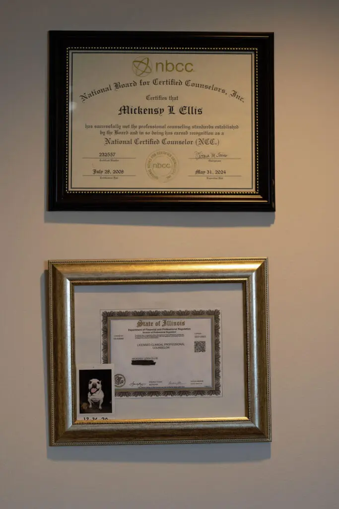 A picture of two certificates hanging on the wall.